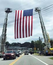 Monroe firefighters raised this American flag high above Route 17M at the Mombasha firehouse last Friday to honor FDNY Lt. Brian Sullivan, a Monroe resident who died Aug. 10.