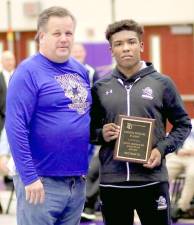 Crusader Marcus Brown receives the Patrick Michael D’Aliso Most Improved Wrestler Award from Tom Kennedy before the finals on Saturday.