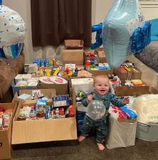 Logan Heidecke celebrated his first birthday on Nov. 11, 2021. He is pictured here at home with all the donations his family collected on his behalf to be delivered to the to the food pantry at the First Presbyterian Church in Chester.