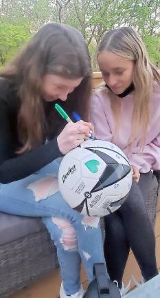 Molly Berman of Warwick and Yirshalem Pinkus of Sugar Loaf work together to design a summer-themed soccer ball for local children with special needs.
