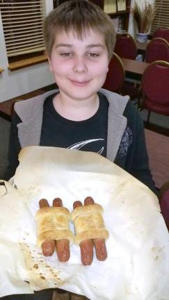 Daniel Askenazy of Highland Mills, 13, shows the “Hot-Torahs” he made at a recent club at Chabad. Hot-Torah’s will be served at Chabad’s OcTORAH Fest deli dinner on Oct. 21.