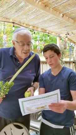 Duvy Burston of Monroe assists Al Muhlrad of Goshen with the shaking the Four Kinds, a mitzvah on the holiday of Sukkot.