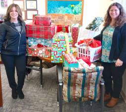 Danielle Moser, a senior public health educator with the Orange County Health Department (left), and Youth Bureau Director Rachel Wilson (right) with gifts for the county’s Adopt-a-Family program.