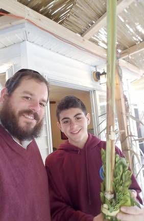 Rabbi Pesach Burston and Gavin Reich of Highland Mills shaking the Four Kinds, a mitzvah on the holiday of Sukkot.