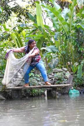Orfelina Portillo casts a fishing net.