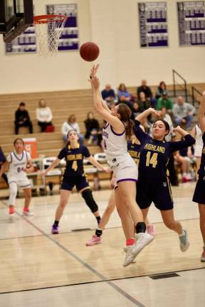Sienna Feeley, #14, spins to the basket past a Huskie defender in the first quarter.