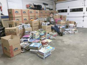 Shanna Sussens poses with the entire collection of more than 6,000 volumes that she is shipping to libraries in South Africa. Photos provided by Alex Carver/MFL.