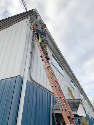 An IBEW 363 electrician works on the external wiring at the CYO building in Washingtonville.
