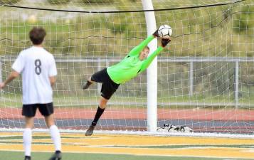 Crusader goalie Parker Giles makes a diving save on a Tiger free kick early in the game. Photos by William Dimmit.