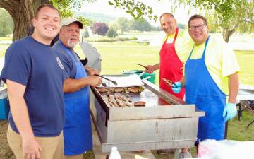 Members of the Momasha Fire Company man the grill for the community barbecue.