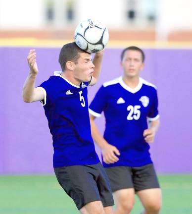 Ethan Meyers (5) heads the ball out of the Crusaders’ zone.