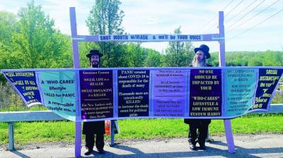 Ben Friedman, with the white beard, and his brother protest masking and social distancing in Kiryas Joel in May.