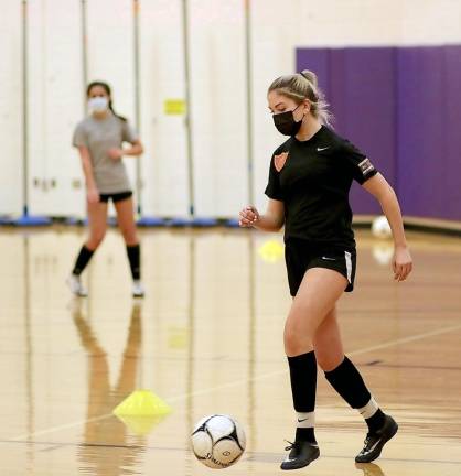 Cassidy Stella moves the ball across the gym floor as the team was forced indoors because of the snow cover.
