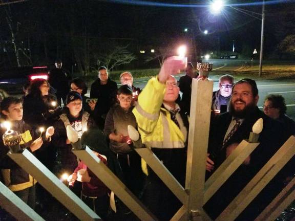 Photos by Dr. Michael Hoffman Tuxedo Town Supervisor Michael Rost lights the &quot;shamash&quot; candle, the first candle, of the menorah outside the Tuxedo Train Station on the second night of Hanukkah.