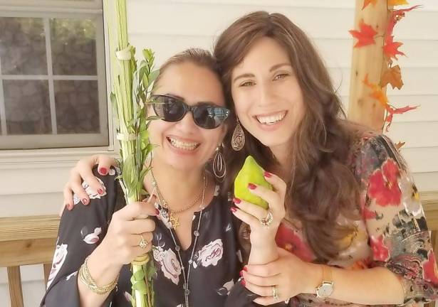 Chana Burston and Jania Brunstein of Monroe shaking the Four Kinds, a mitzvah on the holiday of Sukkot.