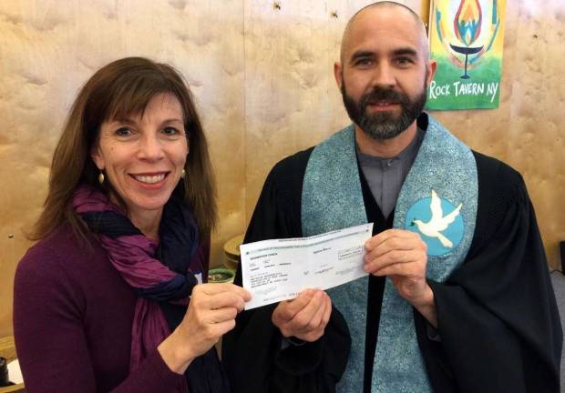 Photo provided by John Kinney Greater Newburgh Interfaith Council refugee Welcome Team Coordinator Alisa Swire and the Rev. Chris J. Antal of the Unitarian Universalist Congregation at Rock Tavern display a check for $10,000 from an anonymous Orange County donor to be used for local refugee resettlement efforts.