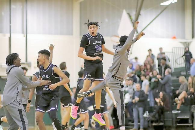 Pablo Quinones leaps in the air as the Crusaders celebrate his game-winning three-point shot at the buzzer.