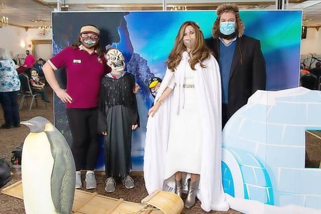 Becky Benezra of Monroe and her son Corey pose for pictures with Rabbi Pesach and Chana Burston at Chabad’s Purim in the Arctic. Photos by Nechamah K Photography.