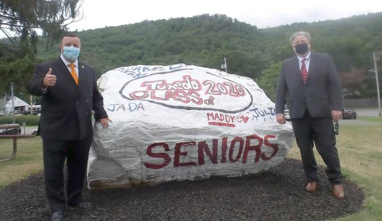 State Assemblyman A. Brabenec and School Board member Dan Castricone pause at the rock before taking their seats.