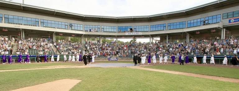 Now pitching for Monroe-Woodbury Crusaders: Faculty and staff enter the field at Palisades Credit Union Park at the beginning of the 2021 graduation ceremony.