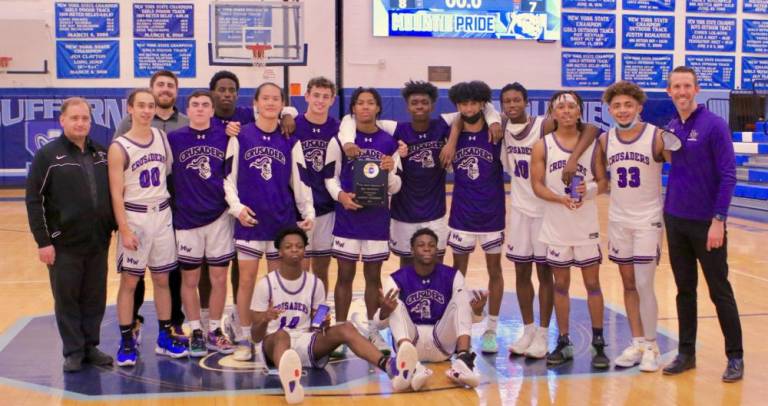 The Crusaders celebrate the Rich Bosco Memorial Tournament victory with Tyace Thompson, who started and finished the game-deciding play, holding the tournament trophy.