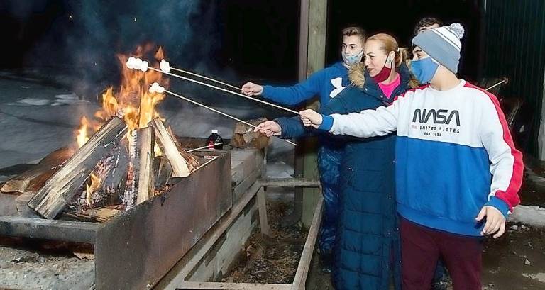 Limor Einav of Monroe and sons Tom and Ethan roast marshmallows at Chabad’s Purim in the Arctic.