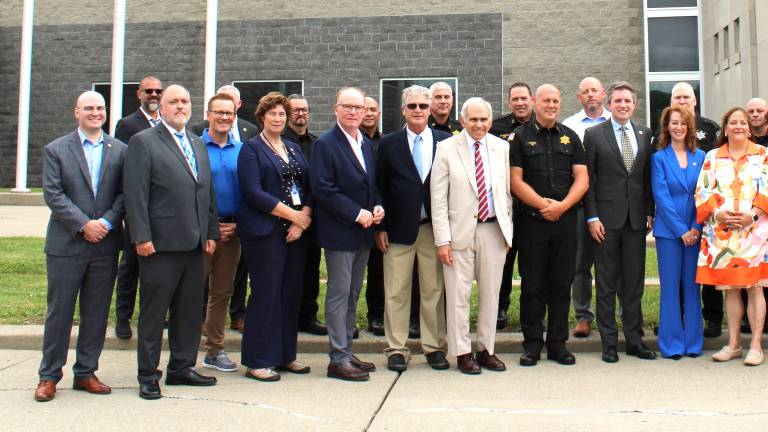Local legislators, law enforcement leaders and others gather at the Orange County Sheriff’s Office to announce the extension of death gamble benefits.