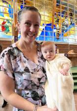 Katlyn Balslov with her daughter Keegan Josephine at the child’s baptism March 30 at St. Stephen’s Church in Warwick, N.Y. Keegan is wearing the same christening gown that her mother wore at her baptism. The gown is made from the silk of a parachute worn in World War II by her great-grandfather. (Photos provided by Denise Cutrona and other members of Camille and Neil McNeil’s family)