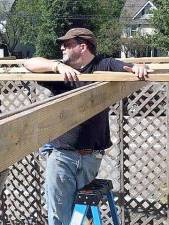 Each year the Men’s Action Club builds a sukkah at Monroe Temple. Pictured here is Rob Lipkin working on the sukkah. Photo by Eben Hill.