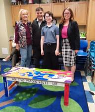 The Monroe Free Library Board of Trustees and executive director received a donated bench that Slade Carlin built and painted for his Bar Mitzvah Project at the April meeting of the Board of Trustees. Pictured from left to right are Patricia Shanley, MFL Board President, Casey Auerbach, MFL trustee, Slade Carlin, and Amanda Primiano, the executive director of Monroe Free Library. Photo provided by Elizabeth Perle/MFL.