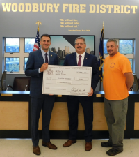 Assemblyman Colin Schmitt, pictured here with Woodbury Mayor Tim Egan and Village of Woodbury Highway Superintendent Robert Weyant, presents a ceremonial check from the state, which awarded the Village of Woodbury a $50,000 grant that will used to fund the construction or modernization of crosswalks in high traffic areas in both business and residential areas and assist in reducing vehicular congestion of roadways.