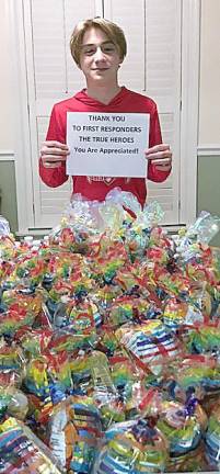 Mason Diltz displays his filled snack bags to be delivered to local first responders.
