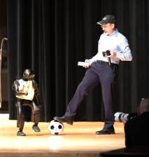 Mobi, a child-sized humanoid AI robot, demonstrates the playful side of autonomous technology by playing soccer for attendees. The summit also featured Sparky, an AI-controlled robotic dog used for emergency management and public safety.