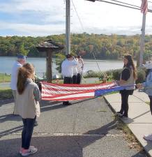 Monroe-Woodbury Cadette Troop 319 assisted American Legion Post 488 officials with the legion’s recent Flag Disposition Ceremony. The legion regularly takes old, tattered flags and disposes of them in a flag-burning ceremony following strict protocols. First, the “old” to be retired flag was flown and honored with the playing of “Taps.” Following the Pledge of Allegiance and playing of the National Anthem, the new flag was hoisted into position. The “retired” flag - which is intended to represent all the flags to be burned - was carried to a location on legion property where it would be burned with other tattered flags dropped off by community members who are knowledgeable about flag disposition. To learn more about how to drop off a flag for proper disposition, call 783-3965. Provided photo.