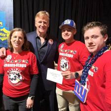 Traci Voelke with NFL Commissioner Roger Goodell and her sons Andrew Voelka and Ben Voelke.