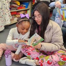 Elementary school and high school students read together.