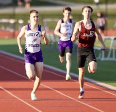 Monroe-Woodbury’s John Urciuoli (#2) passes a Kingston runner at the wire to win the 800 meter race in a home dual meet on April 12, 2023.