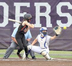 Solid play behind the plate, in the field and at bat by Emma Lawson have kept the the Crusaders undefeated throughout the season. Photos by William Dimmit.