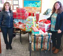 Danielle Moser, a senior public health educator with the Orange County Health Department (left), and Youth Bureau Director Rachel Wilson (right) with gifts for the county’s Adopt-a-Family program.