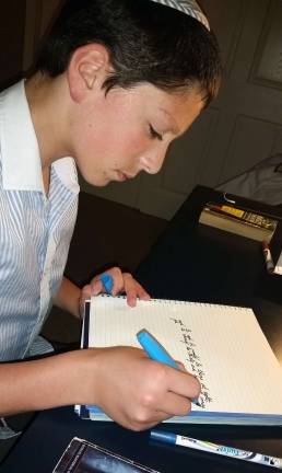 Duvy Burston practices his cursive with the fountain pen prize he won from the International Cursive is Cool Contest.