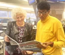 Jeanne Straus (l), publisher of Straus News, looks over a recent issue of the publication with managing editor, Felicia Hodges.
