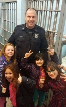 Officer Joseph Ryle of Monroe PD gave a tour to Chabad Hebrew School students through the Monroe Police Department as part of the &#x201c;Cookies for Cops&#x201d; program. He is pictured with Isabella Hauck of Middletown, Ava Reich and Morgan of Highland Mills and Rivkah Burston of Monroe.