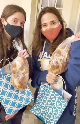 CTeen members Emily Stock and Haley Resti give each teen a “”Shabbat Package” to bring the spirit of Shabbat to their home at Chabad’s CTeen giving event “Tiles for Smiles.”