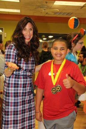 Aiden Axler of Monroe, pictured with Chana Burston, wears his award medallions (Photo provided)