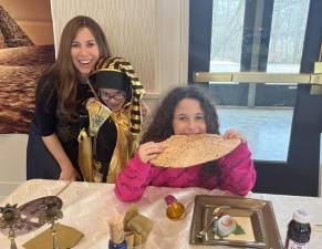 Chabad Hebrew School students Jacob Sentell of Monroe and Sofia Greenberg of Goshen re-enact the Passover Exodus. They are pictured with Chana Burston, director of Chabad Hebrew School.