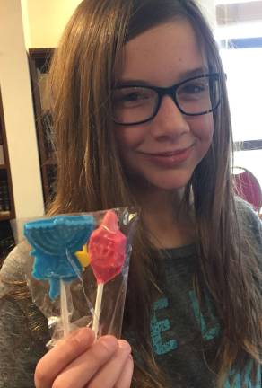 Chabad Hebrew School student Hailey Leonard of Washingtonville proudly displays the Hanukkah-themed colorful chocolate lollipops, as she learned the Hanukkah traditions.