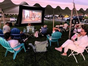 Fans enjoy a showing of “The Goonies” last summer on the lawn next to the Monroe Free Library.