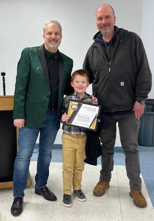 At the Village of Woodbury’s March 13 meeting, Mayor Andrew Giacomzza introduced his first junior deputy mayor: 8 year old Kaedin Freely, who got right to work including board comments. Pictured with the mayor and Freely is Woodbury Fire Department volunteer Anthony Spagna, who presented Freely with a WFD T- shirt.