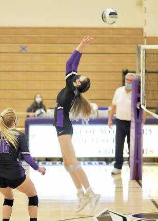 Sophia Ryan (#14) pops the ball backwards over the net.