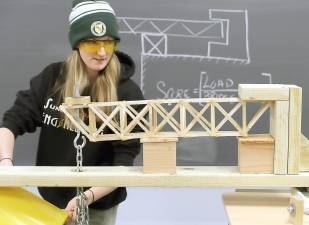 Mikayla Dieterle of Chester watches her popsicle-stick-and-glue bridge start to flex under load testing during the Bridge Breaking contest at SUNY Orange.